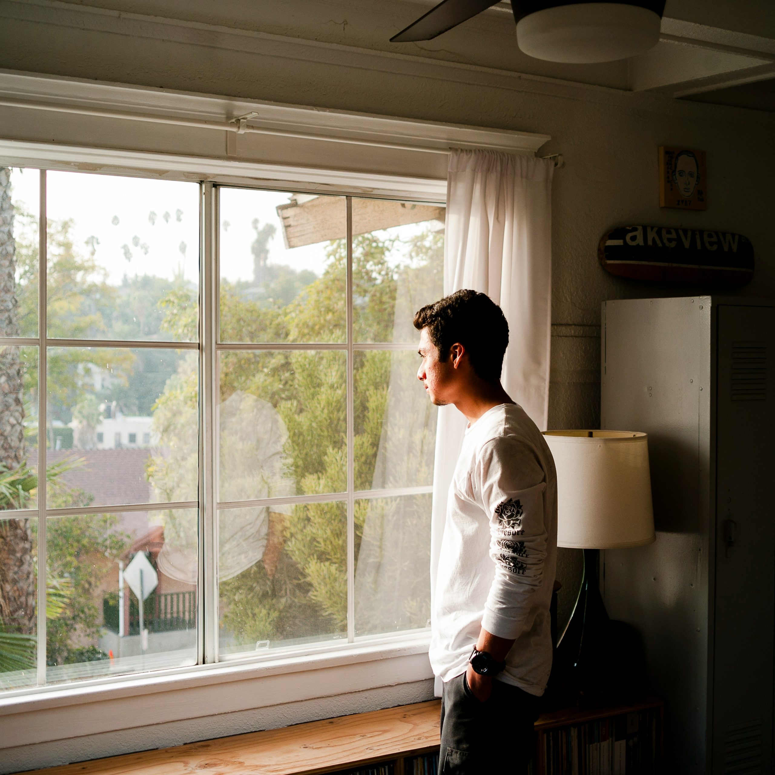man staring out of window