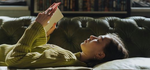 young woman laying down reading a book