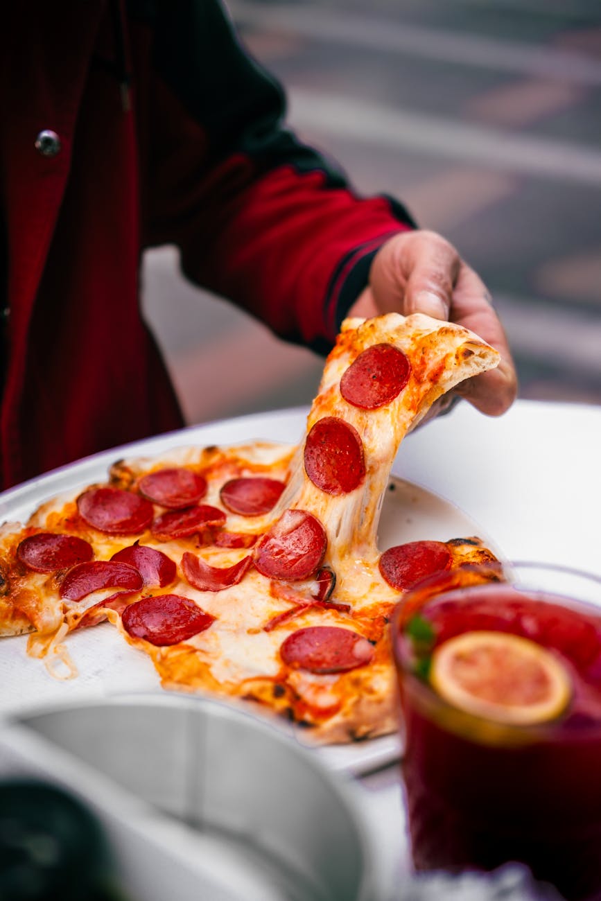 delicious pepperoni pizza slice pulled from tray