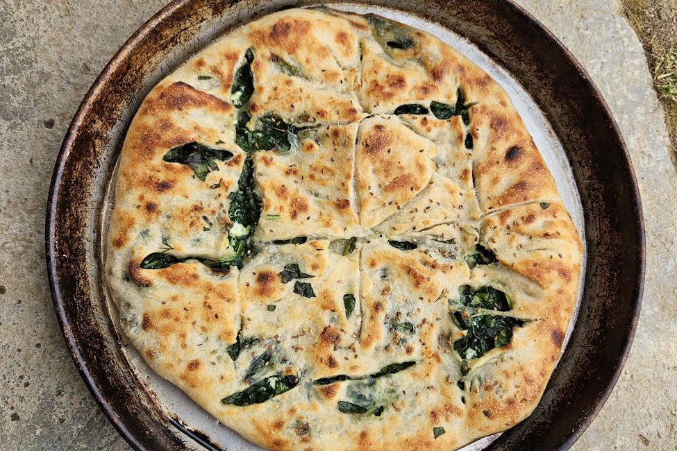 freshly baked spinach flatbread on rustic stone