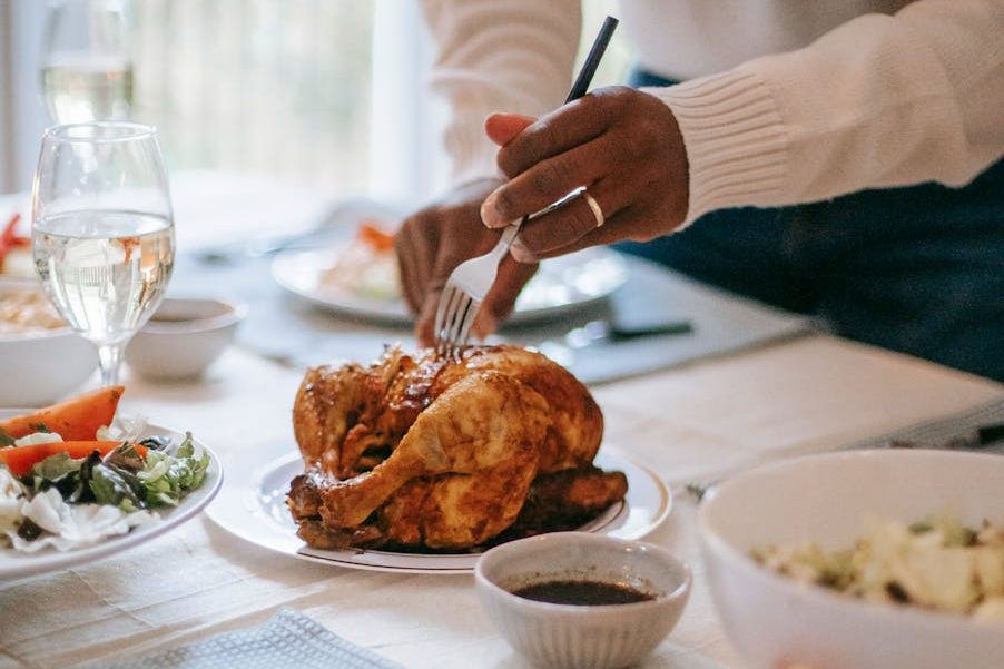 crop black man cutting chicken