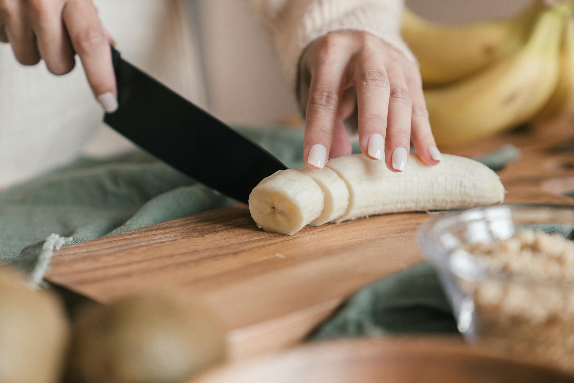person slicing a banana